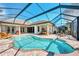 Large kidney shaped pool with screened enclosure and patio area at 4233 Grosse Pointe Dr, Port Charlotte, FL 33953