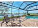 Screened patio with pool, lounge chairs, and lake view at 4233 Grosse Pointe Dr, Port Charlotte, FL 33953