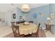 Bright dining room features a round table, neutral decor, and view into the kitchen at 4628 Club Dr # H201, Port Charlotte, FL 33953