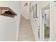 Beige carpeted stairs with coat rack and wall art at 4628 Club Dr # H201, Port Charlotte, FL 33953