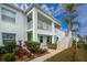Light teal condo building with stairs, balcony, and landscaping at 5725 Greenwood Ave # 6204, North Port, FL 34287