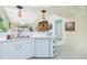 Bright kitchen features white cabinetry, dishwasher, and a breakfast bar at 5725 Greenwood Ave # 6204, North Port, FL 34287