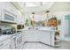White kitchen with ample counter space and view of living room at 5725 Greenwood Ave # 6204, North Port, FL 34287