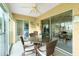 Spacious lanai with glass doors, wicker dining set, and view into bedroom at 5725 Greenwood Ave # 6204, North Port, FL 34287