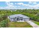 Single-story home with metal roof, large backyard, and lush landscaping at 6153 Pennell St, Englewood, FL 34224