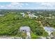 Aerial view showing a house nestled in lush greenery near a waterway at 6153 Pennell St, Englewood, FL 34224