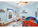 ' bedroom with crib, twin bed, and bookshelves at 6153 Pennell St, Englewood, FL 34224