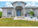 Front view of a single-story house with a blue door and landscaped yard at 6153 Pennell St, Englewood, FL 34224