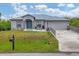 House exterior featuring gray siding, a metal roof, and a landscaped yard at 6153 Pennell St, Englewood, FL 34224