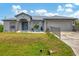 Gray house with metal roof, landscaping, and a two-car garage at 6153 Pennell St, Englewood, FL 34224