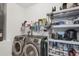 Bright laundry room with washer, dryer, and ample storage shelves at 6153 Pennell St, Englewood, FL 34224