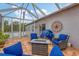 Cozy screened patio with fire pit and wicker furniture at 6153 Pennell St, Englewood, FL 34224