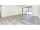 Spacious living room with gray wood-look floors and access to balcony at 66 Boundary Blvd # 280, Rotonda West, FL 33947