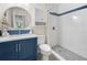 Bathroom with navy vanity, shower, and pebble floor at 660 Linden Dr, Englewood, FL 34223