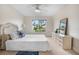 Bright bedroom with white bedding and view of backyard at 660 Linden Dr, Englewood, FL 34223