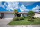 Single-story home with attached garage and lush landscaping at 660 Linden Dr, Englewood, FL 34223