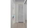 Hallway with light walls, wood-look flooring, and linen closet at 660 Linden Dr, Englewood, FL 34223