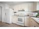 White kitchen with stainless steel appliances and light wood-look flooring at 660 Linden Dr, Englewood, FL 34223