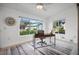 Bright sunroom with multiple windows, a desk, and wood-look flooring at 660 Linden Dr, Englewood, FL 34223
