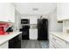 Stylish kitchen with white cabinets, black appliances, and granite countertops at 672 Circlewood Dr # V9, Venice, FL 34293