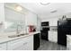 Modern kitchen with black appliances, white cabinets and granite countertops at 672 Circlewood Dr # V9, Venice, FL 34293