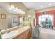 Elegant bathroom with dual sinks, granite countertop, and a soaking tub at 7257 Bridgeport Ln, Englewood, FL 34224