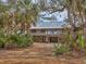 Elevated home with a large deck and lush landscaping at 7475 Manasota Key Rd, Englewood, FL 34223