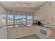 Bright kitchen featuring white cabinets and a window at 812 Seabrooke Dr, Englewood, FL 34223
