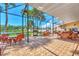 Screened-in community patio with wicker furniture and lake view at 812 Seabrooke Dr, Englewood, FL 34223