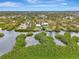 Aerial view of waterfront property with private dock and lush landscaping at 900 Oxford Dr, Englewood, FL 34223