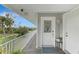 Balcony with white door and railing overlooking green space at 900 Oxford Dr, Englewood, FL 34223