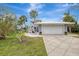 A gray house with a white garage door and palm trees in the front at 900 Oxford Dr, Englewood, FL 34223