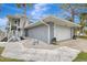 Gray house with white garage door and walkway leading to the entrance at 900 Oxford Dr, Englewood, FL 34223