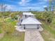 Two-story house with attached garage, paved driveway and tropical landscaping at 900 Oxford Dr, Englewood, FL 34223