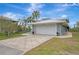 Gray house with white garage door and a paved driveway at 900 Oxford Dr, Englewood, FL 34223