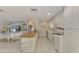 Open kitchen with island, white cabinets, and a view to the living area at 900 Oxford Dr, Englewood, FL 34223