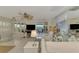 Living room with white sofas, TV, and sliding doors to balcony at 900 Oxford Dr, Englewood, FL 34223