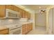 Modern kitchen with light wood cabinets and white appliances at 10045 Links Ln # 203, Rotonda West, FL 33947