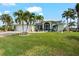 Light green house with palm trees, a large yard, and a two-car garage at 10322 Sunbury Dr, Port Charlotte, FL 33981