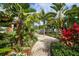 Brick pathway meanders through lush tropical landscaping with palm trees and colorful flowers at 10360 Longshore Rd # 66, Placida, FL 33946