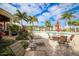 Resort-style pool with lounge chairs, tables, and umbrellas in a tropical setting at 10360 Longshore Rd # 66, Placida, FL 33946