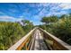 Wooden walkway leading to waterfront with lush vegetation at 10360 Longshore Rd # 66, Placida, FL 33946