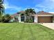 Single-story home with a large yard, attached garage, and a manicured lawn at 1042 Boundary Blvd, Rotonda West, FL 33947