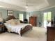 Spacious main bedroom with wood bed frame and access to the pool area at 1042 Boundary Blvd, Rotonda West, FL 33947