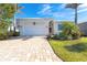 Single-story home with a paver driveway and landscaped front yard at 10479 Coquina Ct, Placida, FL 33946