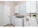 Bright laundry room with washer, dryer, and utility sink at 10479 Coquina Ct, Placida, FL 33946