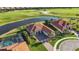 Stunning aerial view of a luxurious home with a pool, lush landscaping, and a golf course in the background at 10705 Tarflower Dr, Venice, FL 34293