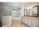 Beautiful bathroom featuring a soaking tub, glass shower, and vanity with granite countertop at 10705 Tarflower Dr, Venice, FL 34293