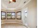 Bright bedroom boasts wood-look flooring, ceiling fan, and windows with wooden shutters at 10705 Tarflower Dr, Venice, FL 34293