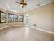 Bright bedroom boasts wood-look flooring, ceiling fan, and windows with wooden shutters at 10705 Tarflower Dr, Venice, FL 34293